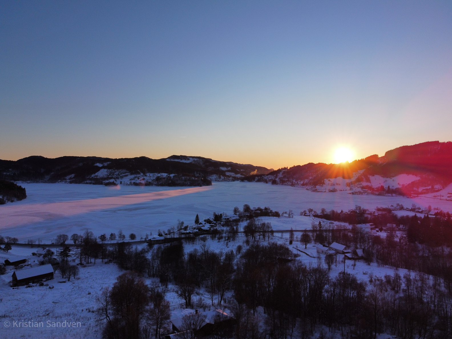 Februar 2021: Solnedgang over et islagt Kalandsvatn (dronefoto).